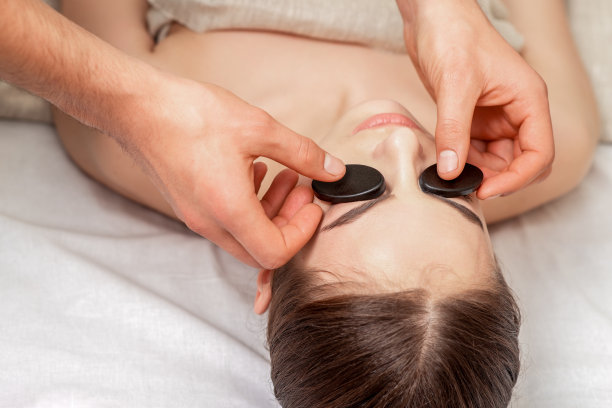 年轻女子接受面部按摩。图片下载