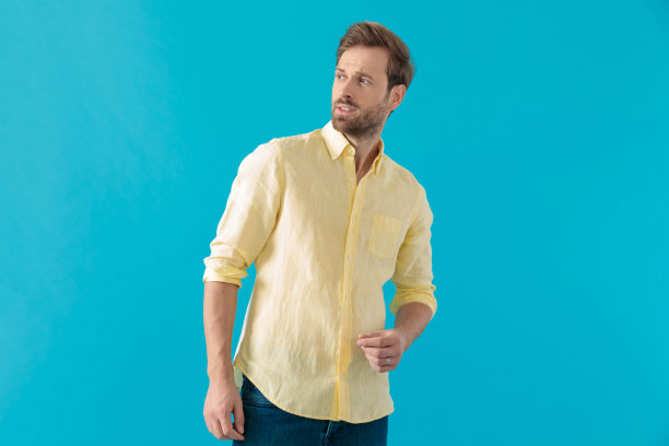 迷人的漫不经心的男人微笑着，好奇地看着别处图片下载