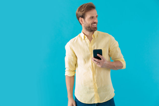 开朗随意的男人微笑着拿着电话图片下载