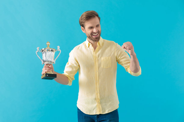 快乐随意的男人笑着拿着奖杯庆祝图片下载