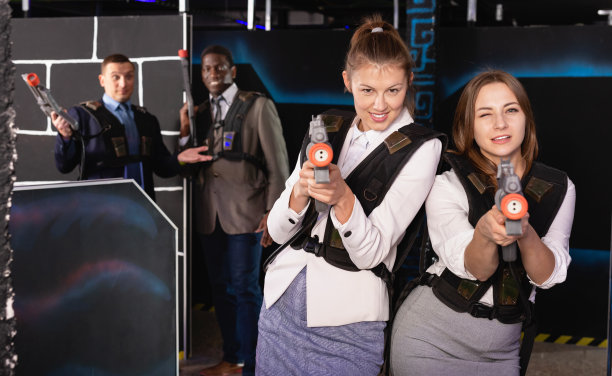 两个穿着西装的女人和同事玩激光枪战的照片图片下载