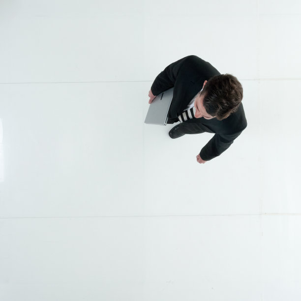 白人年轻男性商人穿着商务装走路，使用笔记本电脑图片下载