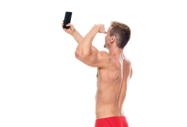 白人年轻男性穿着平角短裤站着玩手机图片下载