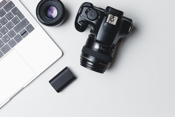 白色背景下的摄影师工作场所。现代笔记本电脑，数码相机，镜头，电池，智能手机。极简主义。前视图。副本的空间。摄影师的设备。自由职业的概念图片下载