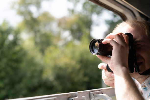 一名身穿夏装的金发成年男子从一辆郊区火车的窗口拍摄照片图片下载