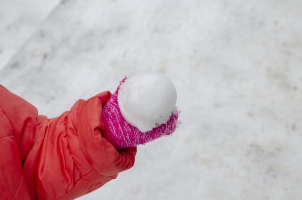 近距离的孩子的手握雪球在冬天图片下载