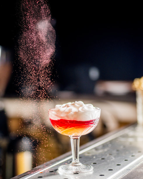 粉红色粉末倒在成品粉红色鸡尾酒上图片下载