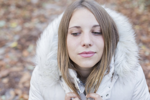 户外肖像，一个美丽的年轻女子看着相机。在秋天摆姿势的女人。日落图片下载