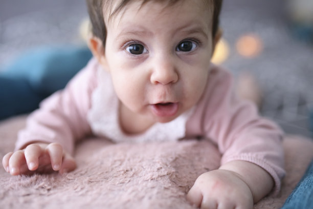 刚出生的女婴在床上玩玩具图片下载