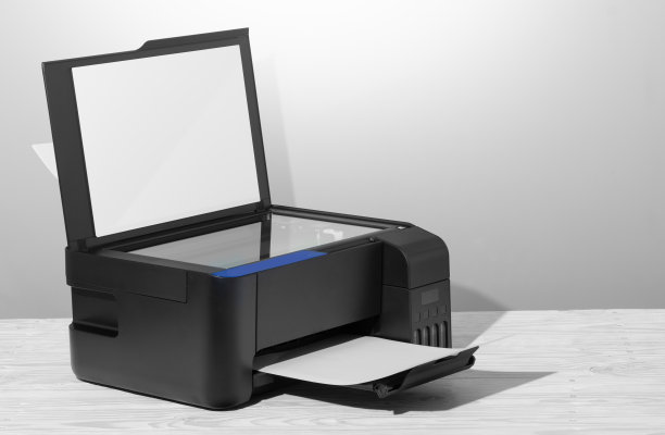 黑色复印机放在白色木桌上，特写。图片下载