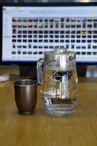 办公室桌子上装有玻璃水罐的纯铜马克杯图片下载