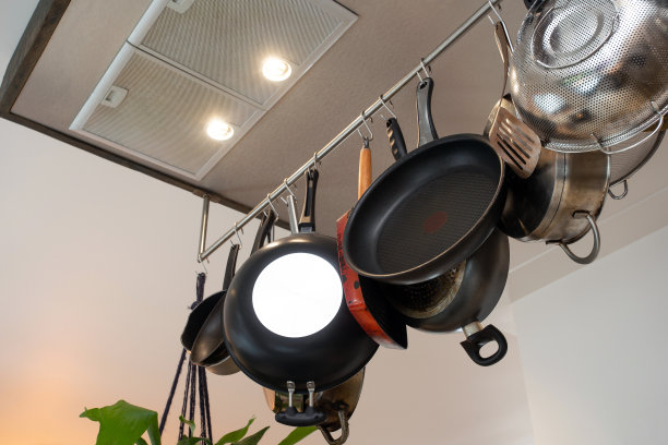 不锈钢炊具，挂在墙上架子上的厨具，煎锅和现代家庭用的平底锅图片下载