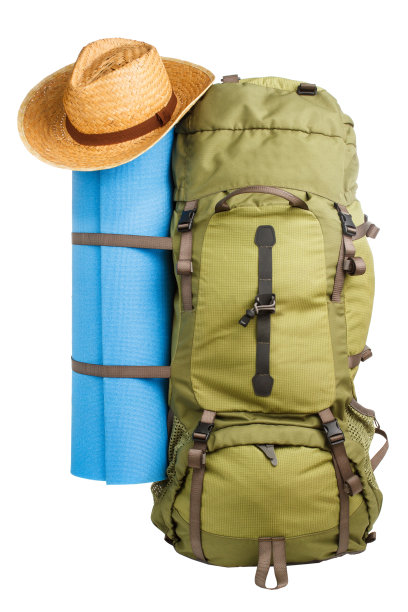 完全包装的大型绿色旅游背包与蓝色露营床和草帽孤立在白色的背景图片下载