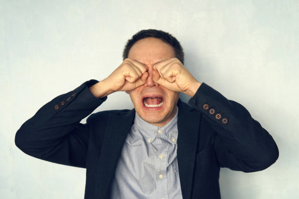 一个年轻商人哭泣的肖像。男人哭起来像个孩子。穿西装的人大张着嘴大叫。心理工作者。图片下载