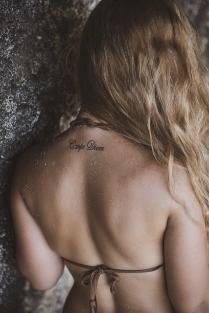 年轻女子背上的“及时行乐”纹身图片下载