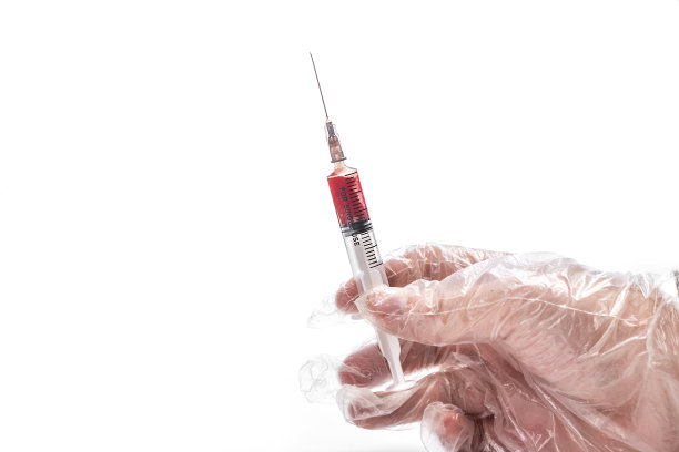 手上拿着一个一次性无菌注射器，里面装满了白色孤立的血液图片下载