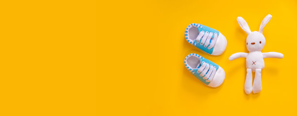 黄色背景的新生儿鞋。有选择性的重点。图片下载