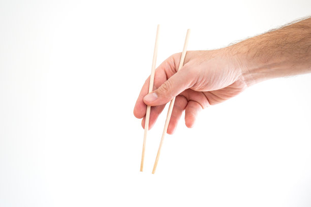 亚洲筷子持白人男性手近距离拍摄孤立的白人图片下载