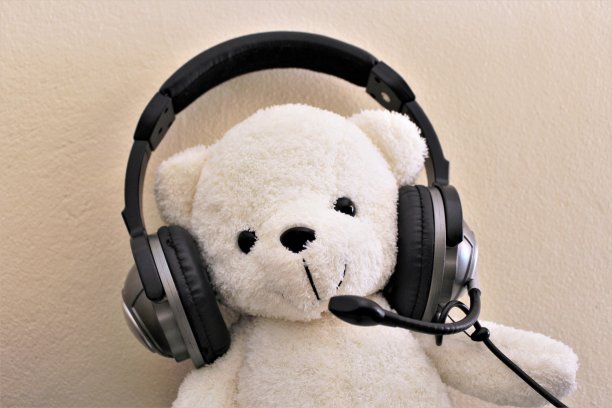白色的泰迪熊戴着耳机图片下载