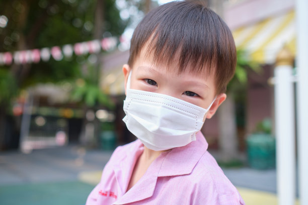 亚洲小男孩在学校戴着医用防护口罩，冠状病毒的概念隔离和空气污染pm2.5的概念图片下载