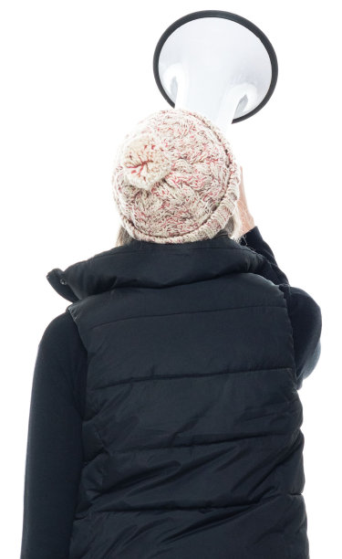 白种年轻女子无袖，穿着夹克衫，手持扩音器图片下载