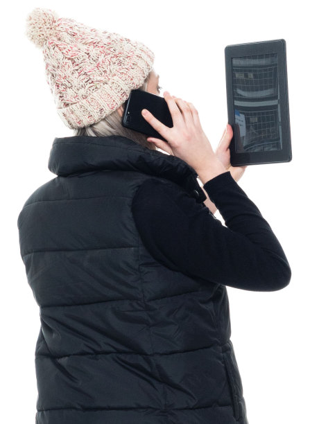 白种年轻女子无袖蹲伏，穿着夹克，使用触摸屏图片下载