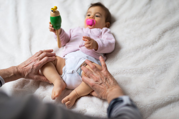 小婴儿接受骨科治疗她的腿，以防止髋关节发育不良的儿科理疗师图片下载