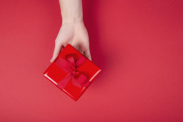 女人的手拿着红色的礼品盒图片下载