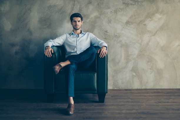 华丽有魅力的企业家的全长照片真正的领袖坐在黑色的皮革扶手椅上好看准备开发大型企业穿白色衬衫裤子棕色鞋子孤立的灰色背景图片下载