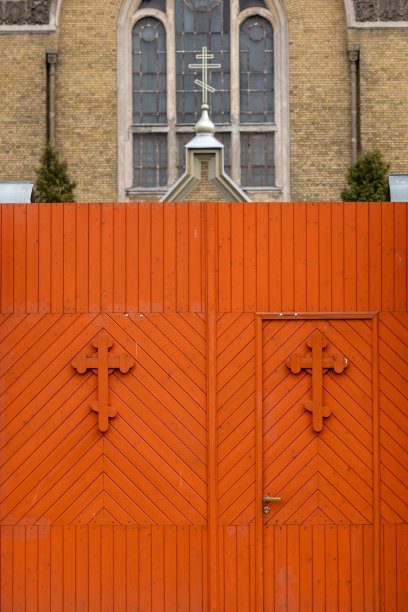 教堂栅栏木门上有橙色的十字架图案图片下载