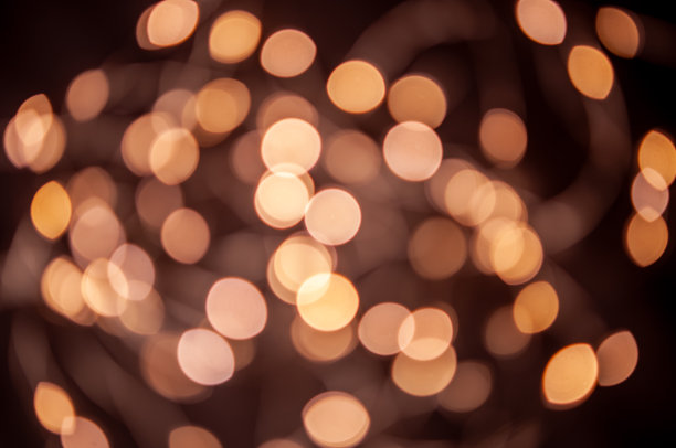 背景是耀眼的花环灯的金色焦。散焦图片下载