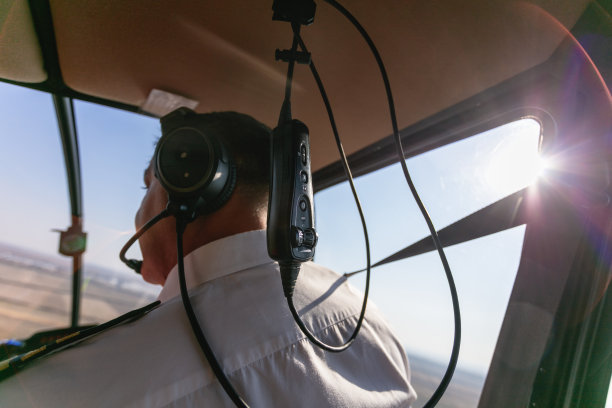 在一个阳光明媚的日子里带着音响设备飞行的直升机飞行员图片下载