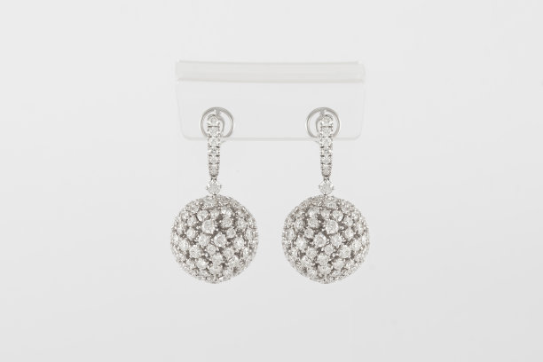 一对白色的黄金钻石耳环在透明的支架。金耳环配钻石，豪华珠宝图片下载