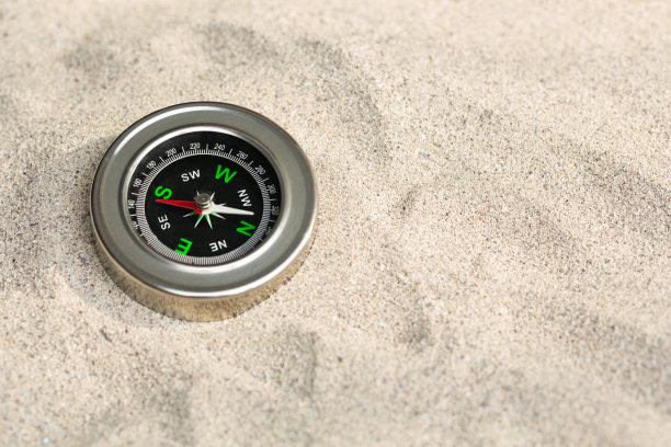 米色海沙上的指南针：旅行复古导航器背景图片下载