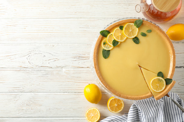 由白色木质背景上的柠檬馅饼组成，俯视图图片下载
