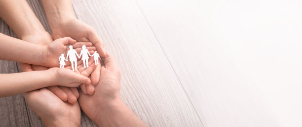 家庭护理的概念。手与纸剪影在桌子上。图片下载