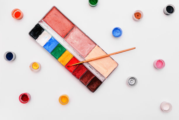 调色板与油漆和画笔在白色的背景。彩色的小罐颜料。一套艺术家化妆和绘画。在绘画和艺术方面的培训。图片下载