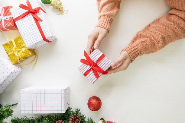 手持礼物和礼物准备，装饰装饰在桌子上。圣诞节、新年、生日庆祝概念。图片下载