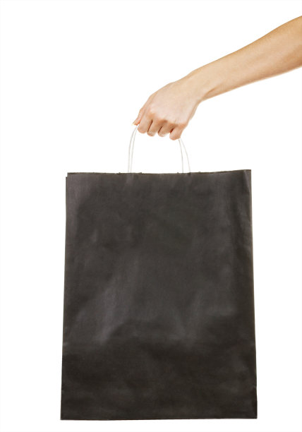 手持黑色纸袋孤立的白色背景。购物的概念。交付的概念图片下载