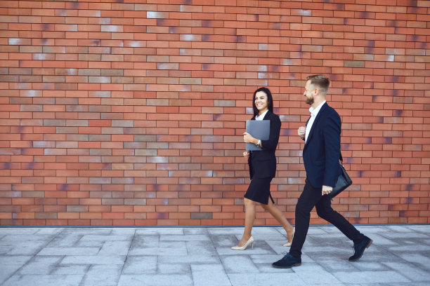 商人站在砖墙背景上。商务工作专业会议的概念。图片下载