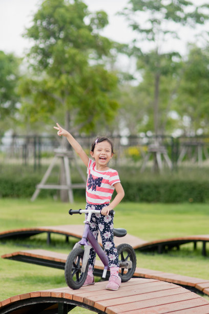 快乐的亚洲小女孩在操场上骑自行车图片下载
