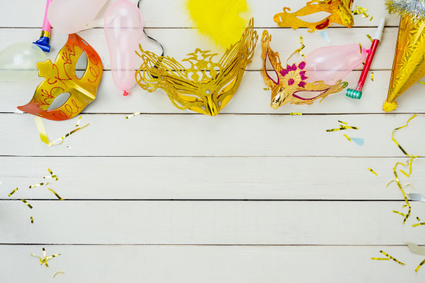 桌面鸟瞰图美丽多彩的狂欢节节日背景。平铺配件对象的几个面具和装饰五彩纸屑在现代白色木制的家庭办公室办公桌工作室。副本的空间。图片下载