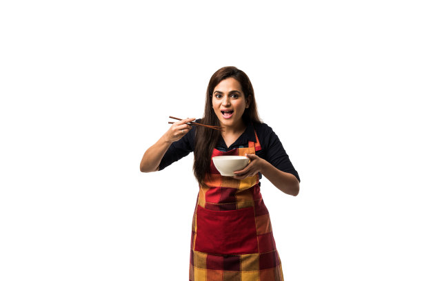 印度女厨师用围裙拿着用筷子夹着的空碗，吃或展示，孤立地站在白色的背景上图片下载