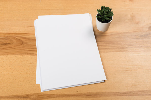 俯视图的现代办公桌办公场所与a4纸。品牌空白模板。照片空白表格。为作品集设计模拟。图片下载