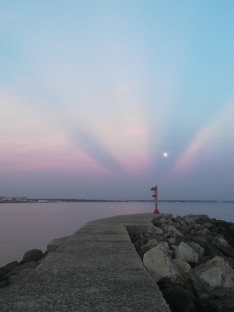 粉红色阳光下的灯塔、月亮和码头图片下载