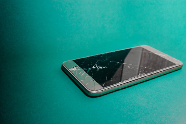 破碎的智能手机屏幕。在单一颜色的蓝色薄荷背景上的破碎设备的三维照片图片下载