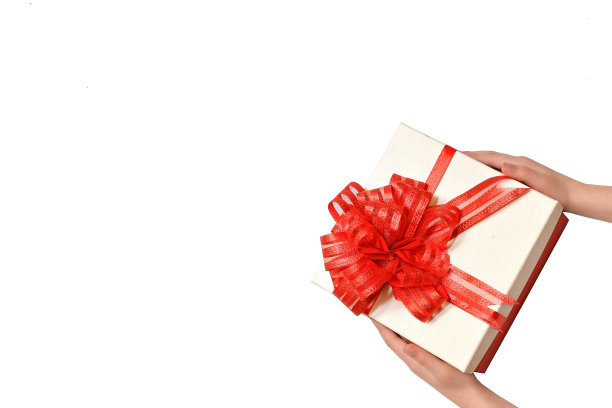 美丽的礼盒与一个蝴蝶结在女性的手在一个白色的背景图片下载