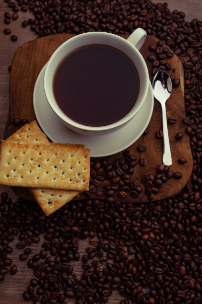 咖啡杯和饼干放在桌子上图片下载