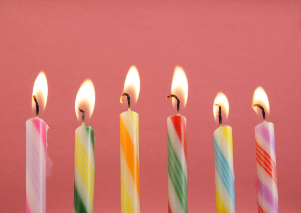 粉红色背景上的彩色生日蜡烛图片下载