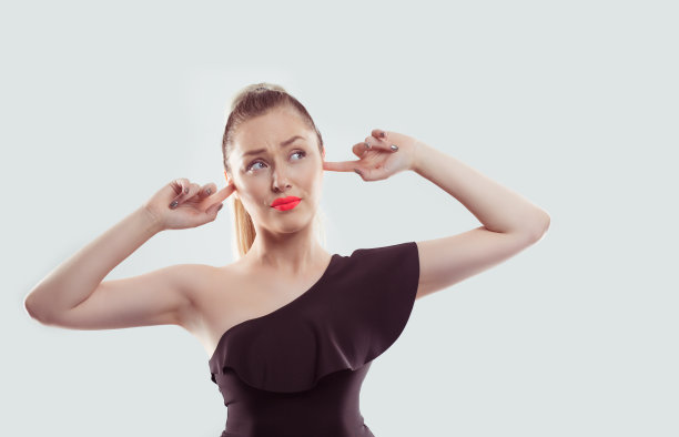 压力沮丧的女人用手捂着耳朵向上看孤立的白色浅蓝色背景图片下载